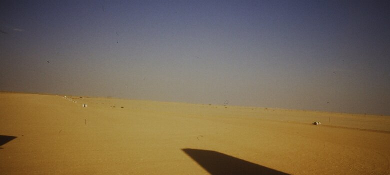 1987: Oman par Jacques Bernaux depuis le Fokker, vue sur la piste de l'aéroport de Marmul; les pistes sont balisées par d'anciens futs de carburants peints en blanc avec une bande blanche...